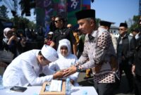 Penjabat Gubernur Jawa Barat Bey Machmudin menjadi saksi nikah pada kegiatan nikah massal dalam rangkaian West Java Festival 2024 di kawasan Gedung Sate, Kota Bandung, Sabtu (24/8/2024).